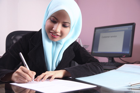 Businesswoman writing on documentの写真素材