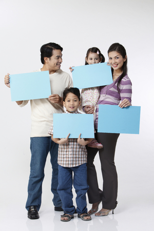 family holding a card facing cameraの写真素材