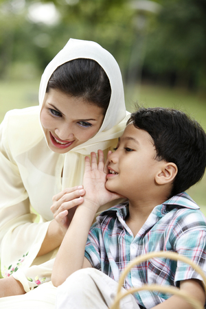 boy whispering  to the mothe rat parkの写真素材