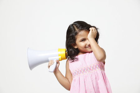 Little girl holding loud speakerの写真素材
