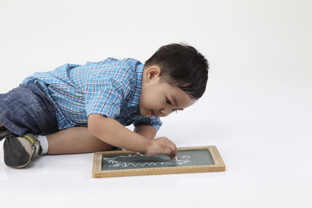 boy drawing at black boardの写真素材