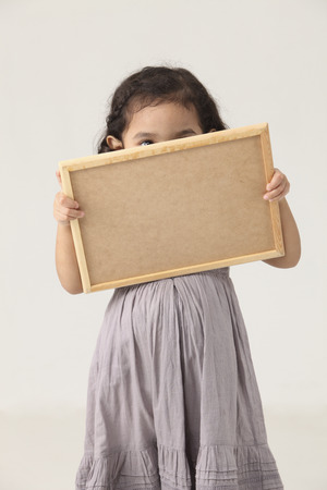 Portrait of girl looking at blackboardの写真素材