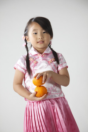 Chinese girl holding mandarin orangesの写真素材
