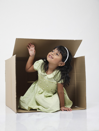 Little girl coming out from the boxの写真素材