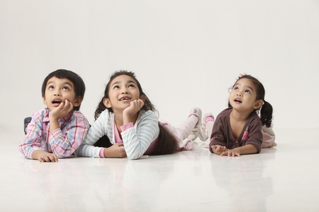 Happy Siblings Lying on Front, looking upの写真素材