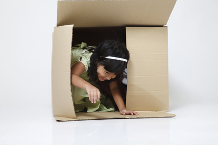 Little girl coming out from a boxの写真素材