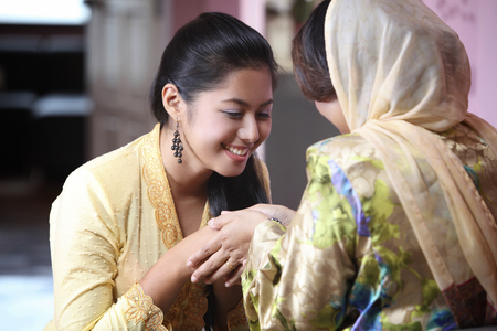 Daughter shake hand with her motherの写真素材