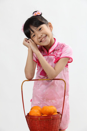 cute chinese girl with basket of tangerineの写真素材