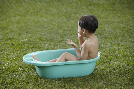 malay boy taking his bath outdoorの写真素材