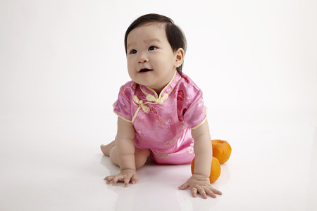 chinese baby with cheongsam crawling on the white backgroundの写真素材