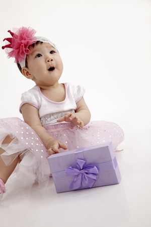 chinese baby wearing party dress with purple gift boxの写真素材
