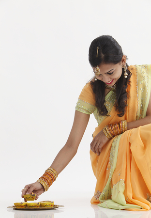 Indian woman in glamorous traditional clothing holding oil lampの写真素材