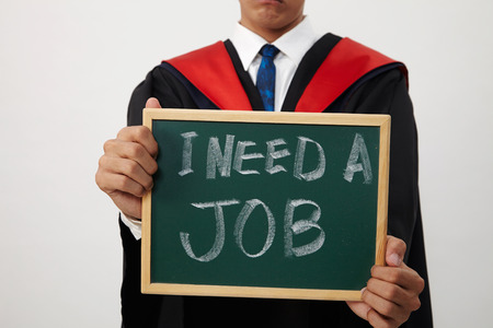 malay graduated student holding a blackboard written need a jobの写真素材