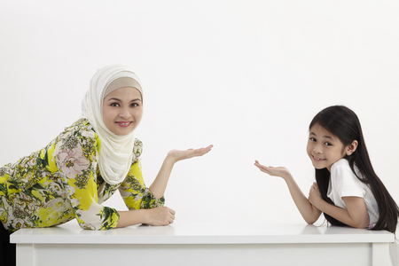 mother daughter raised arm presentingの写真素材