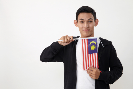 malay teenage holding a small malaysiasia flagの写真素材