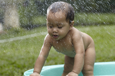 malay baby having fun- outdoor bathの写真素材