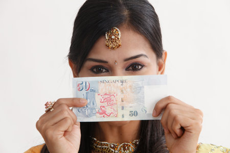 inadin woman in saree holding Singapore cash notes