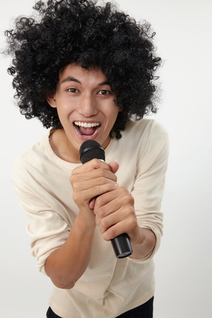 man holding a wireless microphone singingの写真素材