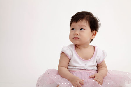 chinese baby girl with party dress sitting