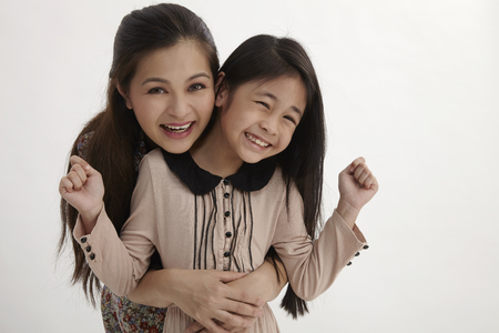 malay mother hugging little daughter from the backの写真素材