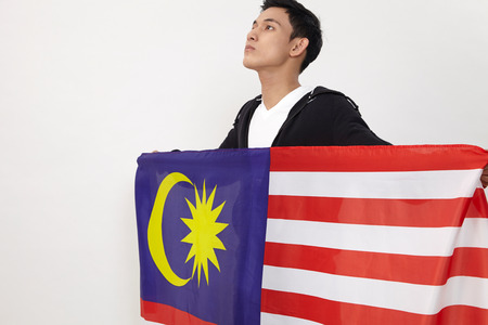 young malay teenage holding malaysia flagの写真素材