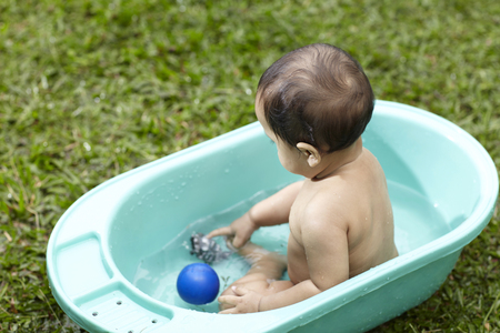 malay baby having fun- outdoor bathの写真素材