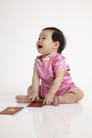 chinese baby wearing cheomgsam sitting in the studioの写真素材
