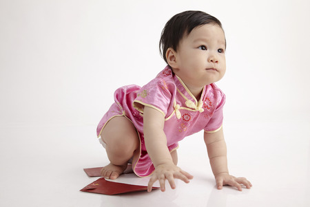 chinese baby wearing cheomgsam crawling in the studioの写真素材