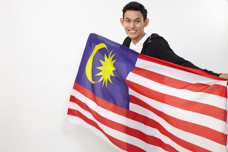 young malay teenage holding malaysia flagの写真素材