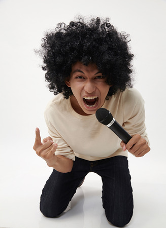 man holding a wireless microphone singingの写真素材