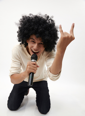 man holding a wireless microphone singingの写真素材