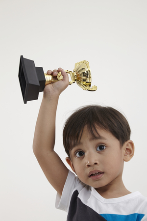malay boy holding a trophyの写真素材