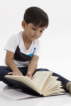 Malay boy sitting reading bookの写真素材