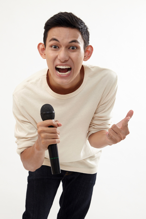 man holding a wireless microphone singingの写真素材