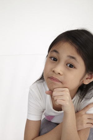 kid squatting down and looking upwardの写真素材