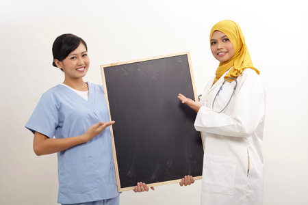 asian female doctor and nurse holding blackboardの写真素材