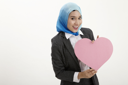 malay business woman with tudung holding a heart shaped placardの写真素材