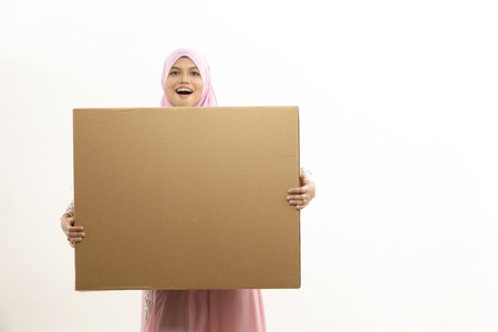 malay woman with tudung holding brown box on white backgroundの写真素材