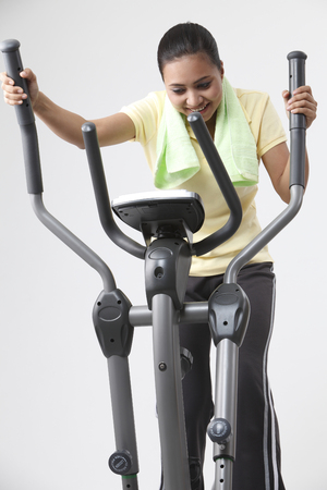 Malay woman cycling on the exercise bike.の写真素材