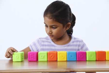 Little girl arranging Abc blocks in a rowの写真素材