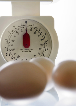 Some eggs placed in front of a scaleの写真素材