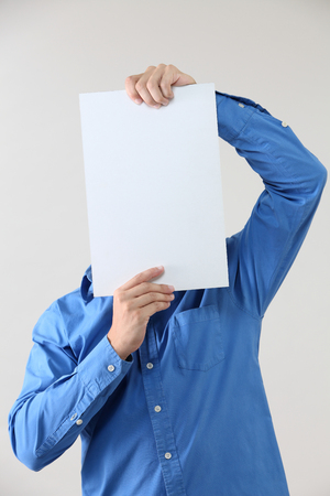Man holding blank paper cover the faceの写真素材