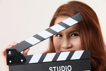 woman hiding behind the film slateの写真素材