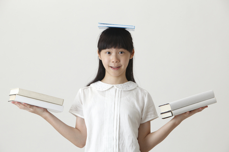 chinese girl balancing with booksの写真素材