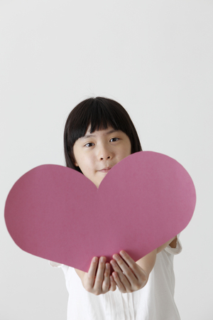 chinese girl holding a blank heart shape cardboardの写真素材
