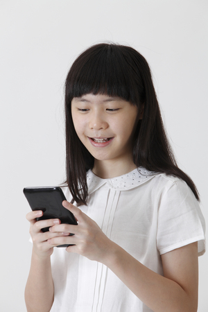 chinese girl sending text message with mobile phoneの写真素材