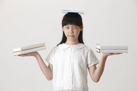 Chinese girl balancing booksの写真素材