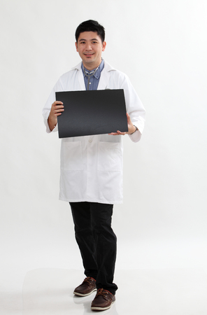 full length chinese doctor holding a blank cardの写真素材