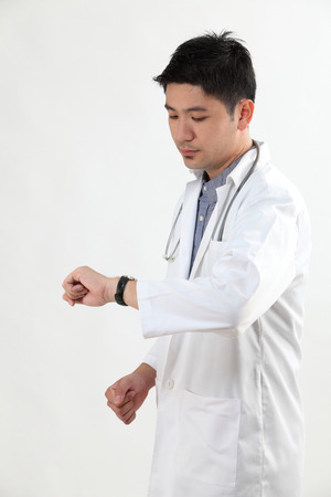 chinese doctor looking at the watchの写真素材
