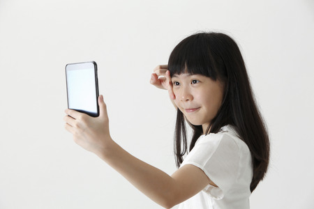 chinese girl self portrait with smart phoneの写真素材